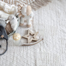 Set of children's stylish handmade knitted clothes with various accessories in the boho style, top view.